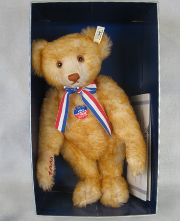 Large teddy bear with ribbon and embroidered paws