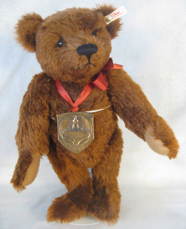 Brown bear with a medal on an orange ribbon
