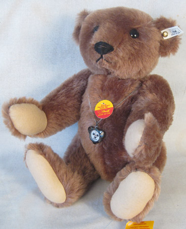 Brown teddy bear wearing a gunmetal pendant watch