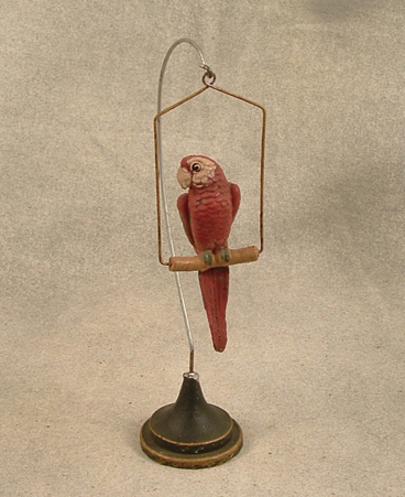 Red Elastolin parrot on hanging perch with stand